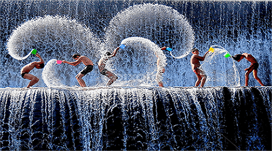 Kids playing water near waterfall